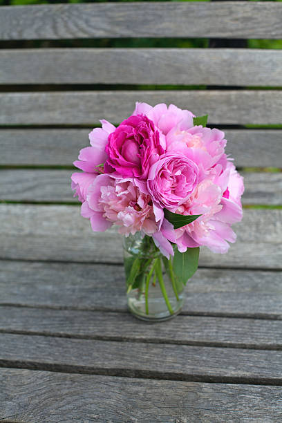 istock peony and rose bouquet on wooden surface 513902621