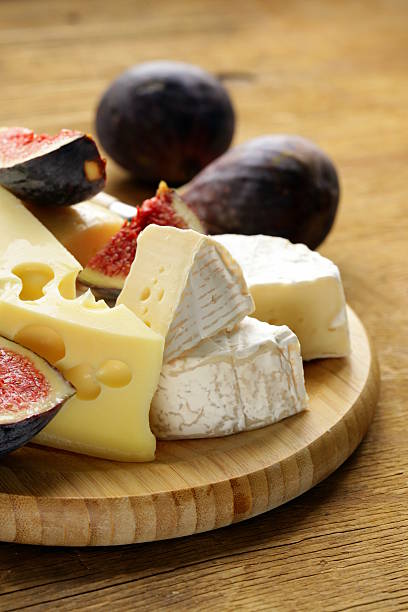 cheeseboard with maasdam, camembert, cheddar cheese and figs