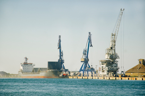 A harbour with high cranes and a cargo ship
