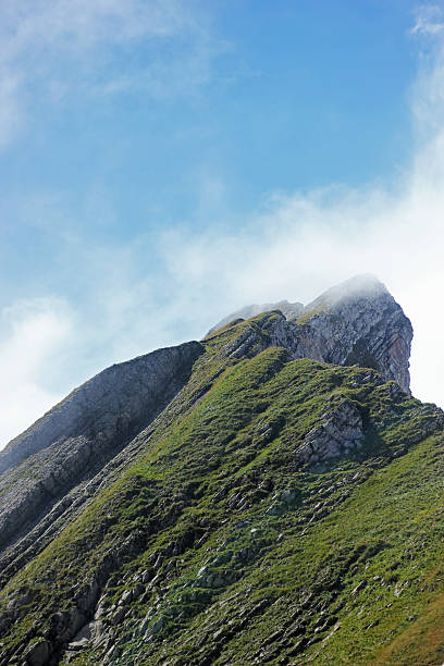 Mountaintop rise into cloudy blue sky stock photo