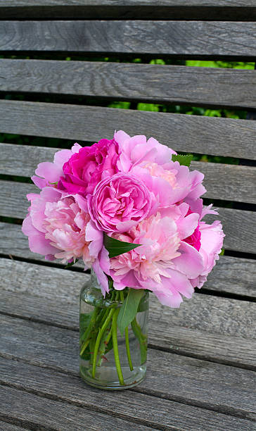 istock peony and rose bouquet on wooden surface 513906385