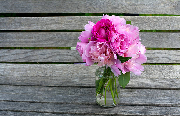 istock peony and rose bouquet on wooden surface 513906735