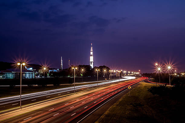Space Camp Interstate Traffic blurs by the Saturn 5 rocket on display at the Space and Rocket Center huntsville alabama stock pictures, royalty-free photos & images