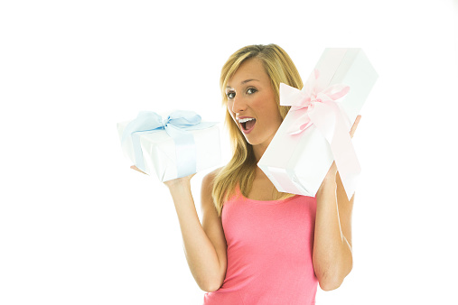 Young woman on white background holding white gift with blue ribbon and white gift with pink ribbon.