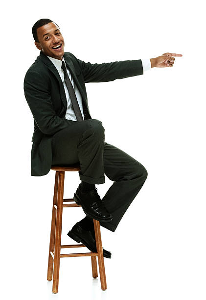 istock Smiling businessman on stool & pointing away 513922599