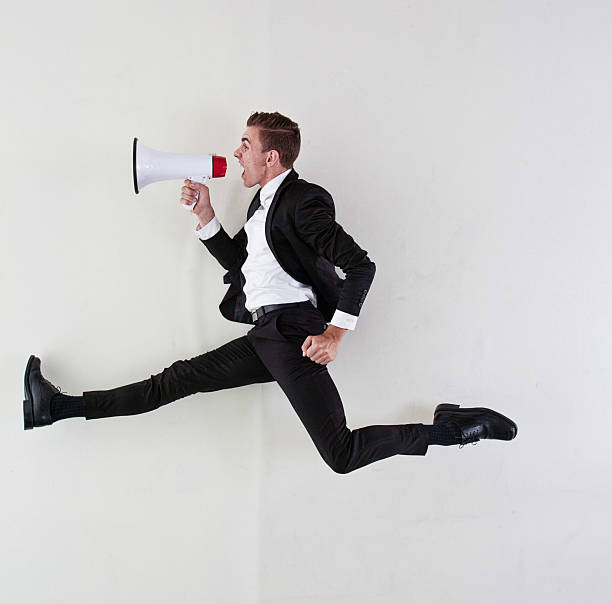 istock Businessman jumping & shouting with megaphone 513922629