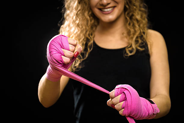 istock Woman is wrapping hands with pink boxing wraps 513934392