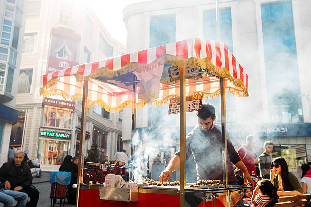 Istanbul, Turkey - October 25, 2014: Chestnut roasting chestnuts  a customer. Roasted chestnut is a popular street food in Istanbul, enjoyed both by locals and tourists.