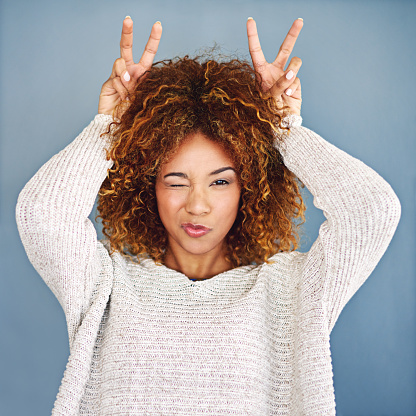 Studio shot of a young woman making a bunny ear gesture against a grey backgroundhttp://195.154.178.81/DATA/i_collage/pi/shoots/806454.jpg