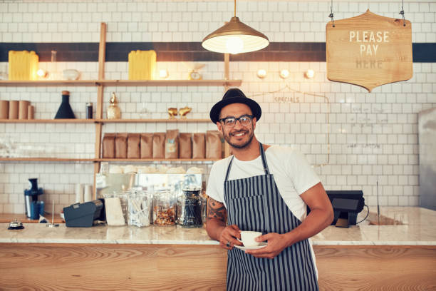 istock Barista standing at bar counter and smiling at camera 513942756