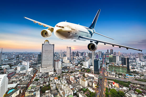 istock Airplane over cityscape 513943562
