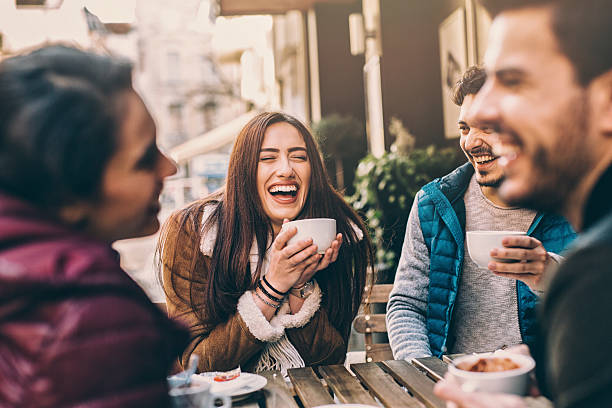 grupo de amigos hablando y riendo - couple outdoors coffee friendship fotografías e imágenes de stock