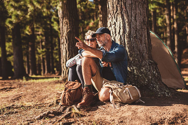 starszy turystów kempingowe w lesie - hiking senior adult couple heterosexual couple zdjęcia i obrazy z banku zdjęć