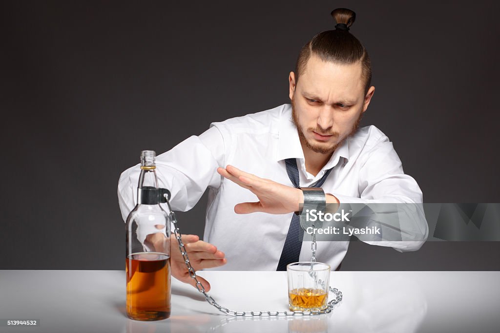 Alcohol dependence in men Young handsome man refuses to drink alcohol and alcohol dependence. Addicted to alcohol, alcoholism concept, social problem Abuse Stock Photo