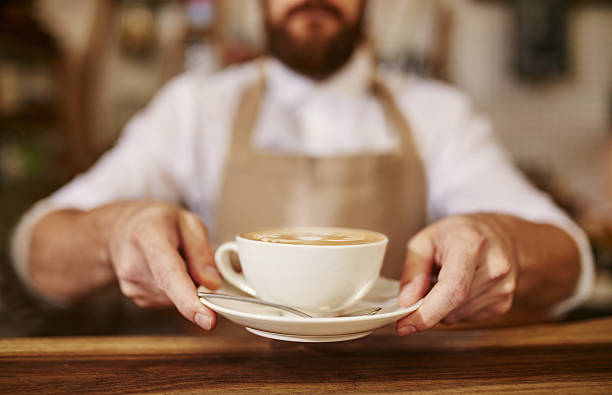 barista ofrece una taza de café recién preparado para usted - servir comida y bebida fotografías e imágenes de stock