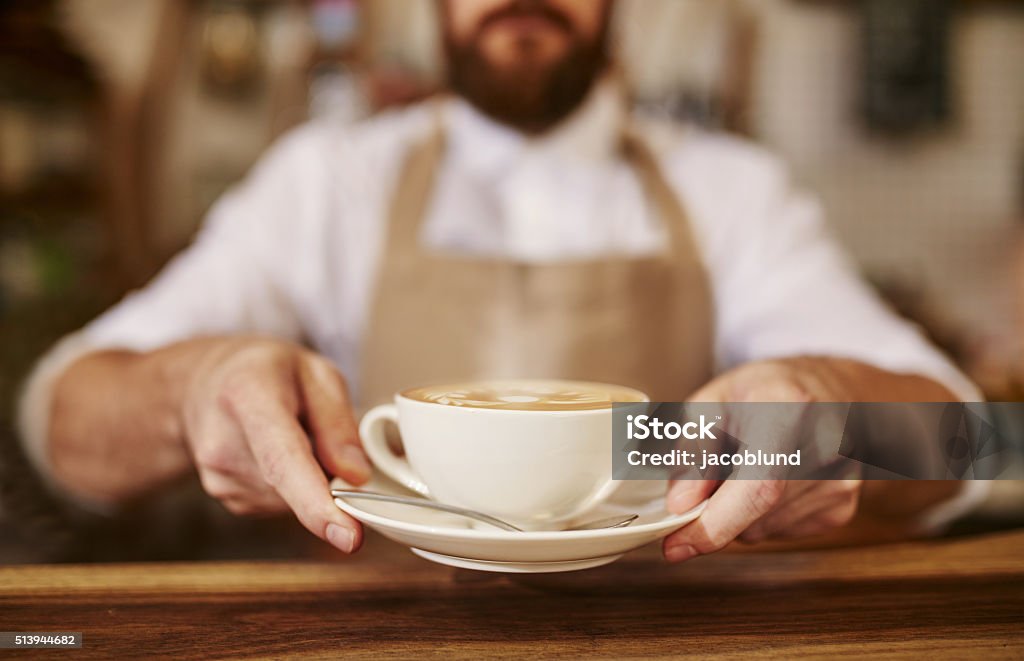 Barista serving cup of fresh coffee for you Close up of male barista serving cup of fresh coffee. Cup of coffee in the hands of waiter. Coffee - Drink Stock Photo