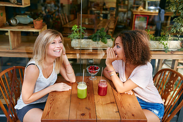 istock Young female friends having private gossips at cafe 513944970