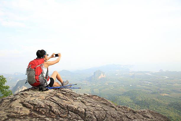 istock young woman backpacker taking photo with cellphone on mountain peak 513945406