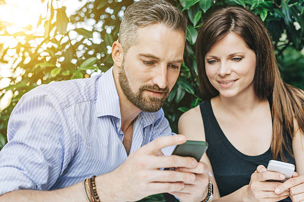 istock Young happy couple looking at mobile phone 513946566