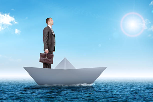 istock Businessman in paper boat 513948194