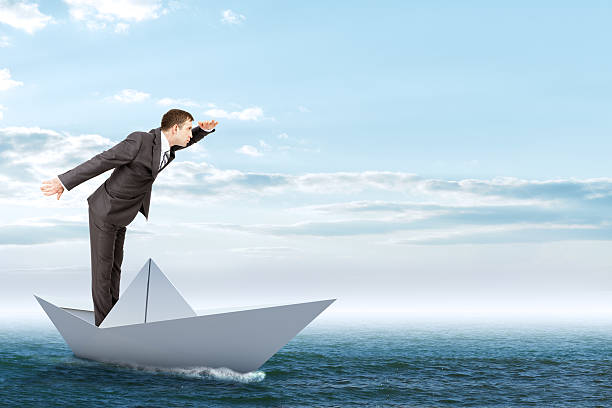 istock Businessman in paper boat 513948318