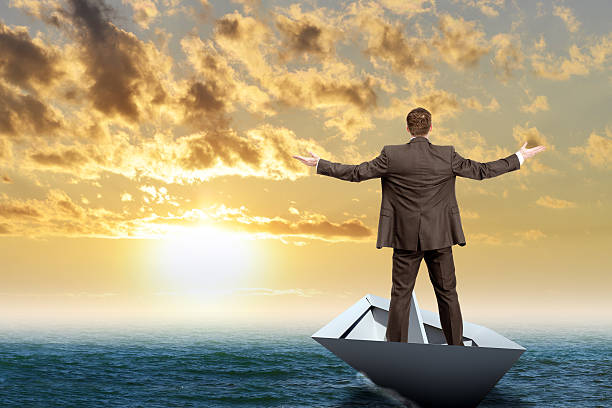 istock Businessman in paper boat 513948746