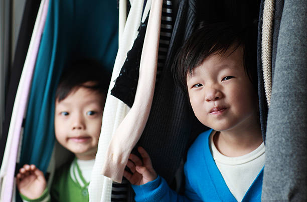 istock Brother playing in the closet 513951546