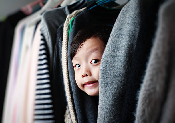 Child playing in the closet Cute asia children hiding stock pictures, royalty-free photos & images