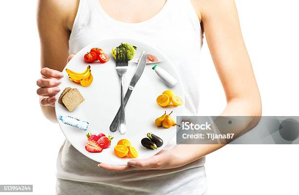 Beautiful Young Woman Holding A Plate With Food Stock Photo - Download Image Now - Healthy Eating, Dieting, Clock