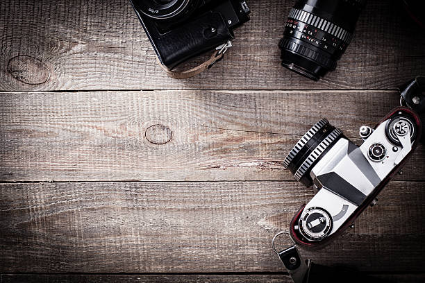 istock Old SLR camera and leather case on wooden table. 513954790