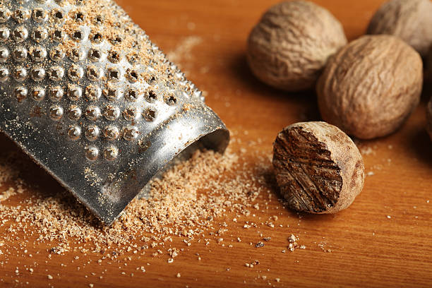 Grated Nutmeg Whole and grated nutmeg with small grater nutmeg stock pictures, royalty-free photos & images