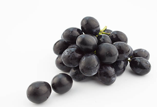 istock Small bunch of black grapes isolated on white background 513955254