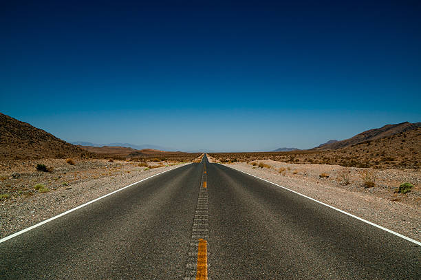 istock desert road highway in death valley national park 513960509