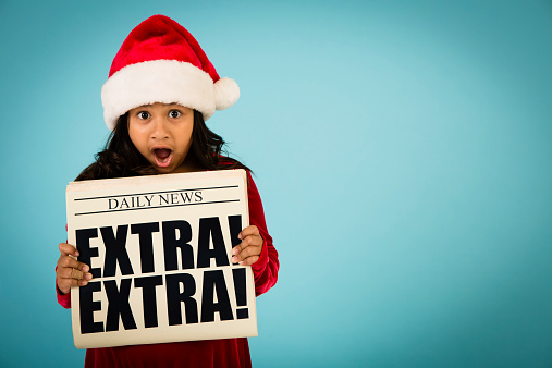 Color image of a young girl, wearing a Santa hat, while holding a newspaper and making a stressed/shocked face. Includes room for your text.