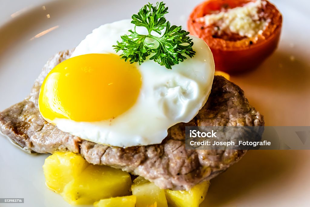 Sirloin steak topped with fried egg and breakfast potatoes Breakfast Stock Photo