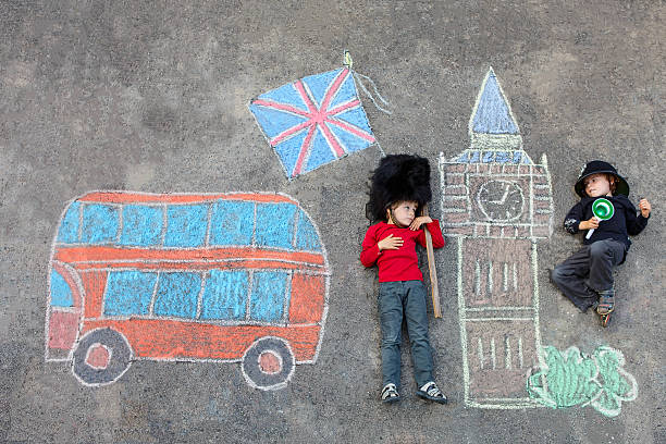 istock Two little kids with London picture drawing with chalks 513983784