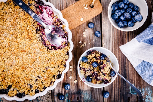 homemade blueberry crumble with oatmeal on wooden table