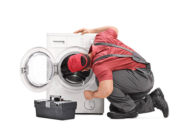 istock Repairman examining a washing machine 513986784