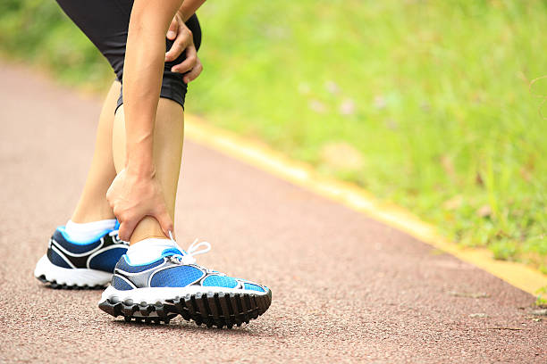 istock woman runner hold twisted ankle 513989087