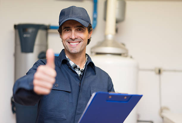 Smiling plumber portrait Smiling technician servicing a hot-water heater Plumber stock pictures, royalty-free photos & images