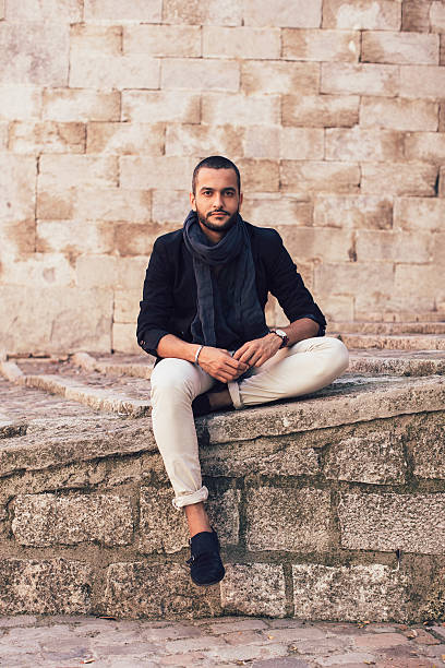 istock Stylish man sitting on steps and looking at camera 513994484