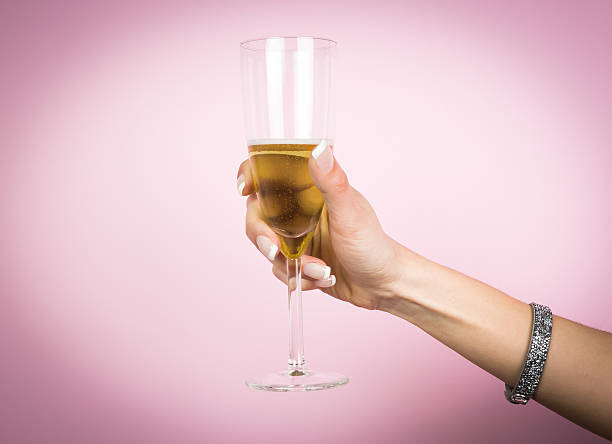 mão de mulher com copo de champanhe, isolado em uma rosa - toast glass cut out human hand imagens e fotografias de stock
