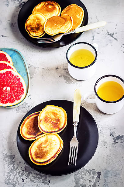 istock Fritters in black plates and two mugs of tea. 514004014
