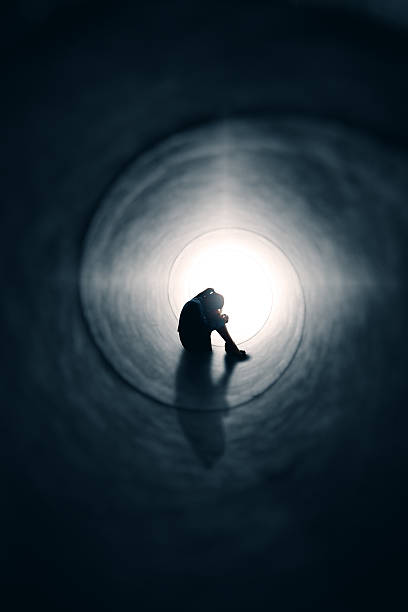 uomo anziano depresso donna nel tunnel di luce - women sadness depression fear foto e immagini stock