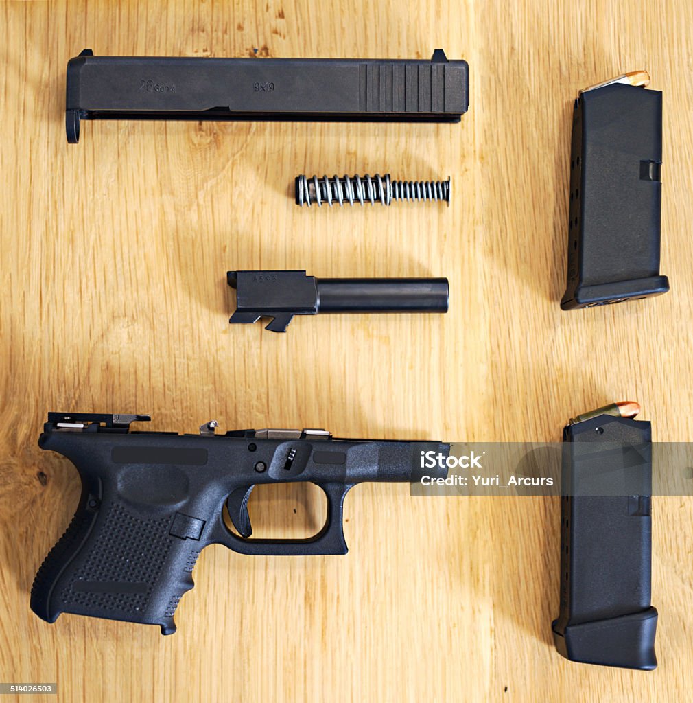 Ready for assembling A shot of a disassembled gun lying on a table top Disassembling Stock Photo