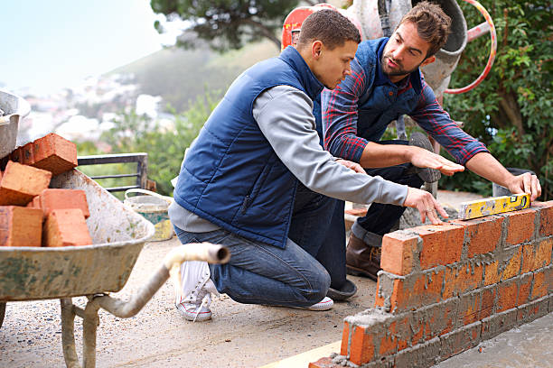 Making strong foundations Shot of bricklayers at work mason craftsperson stock pictures, royalty-free photos & images