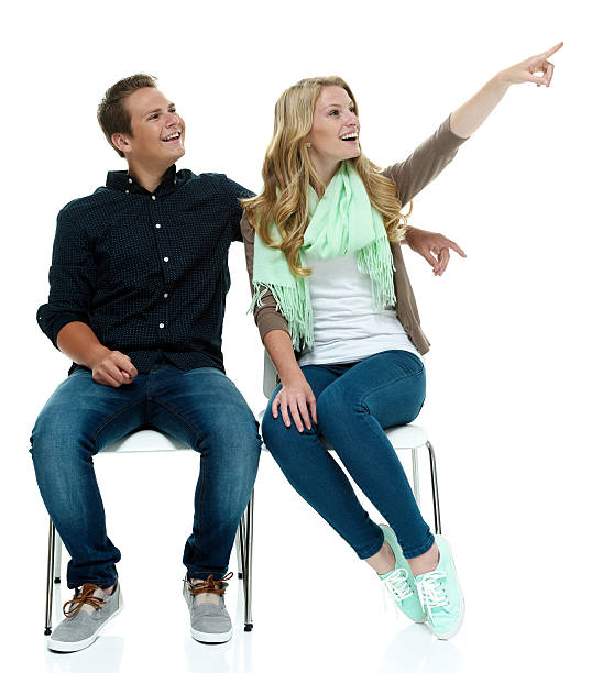 istock Cheerful couple on chair & pointing away 514027761