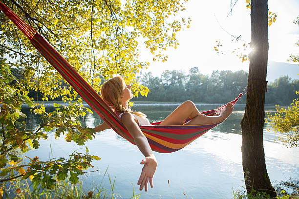 istock Woman relaxing on hammock by the river at sunset. 514027777
