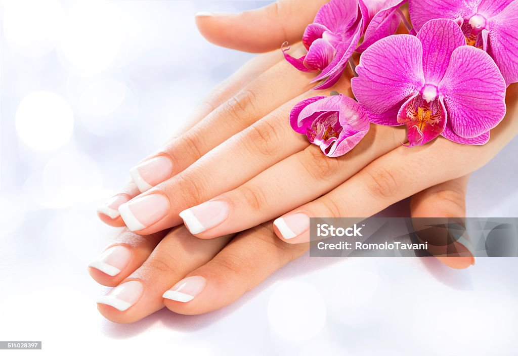 manicure and beauty treatment french manicure with pink orchids Fingernail Stock Photo