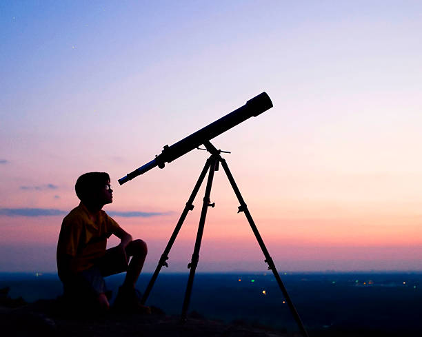 Telescope A young boy looking thru a telescope at sunset. astronomer photos stock pictures, royalty-free photos & images